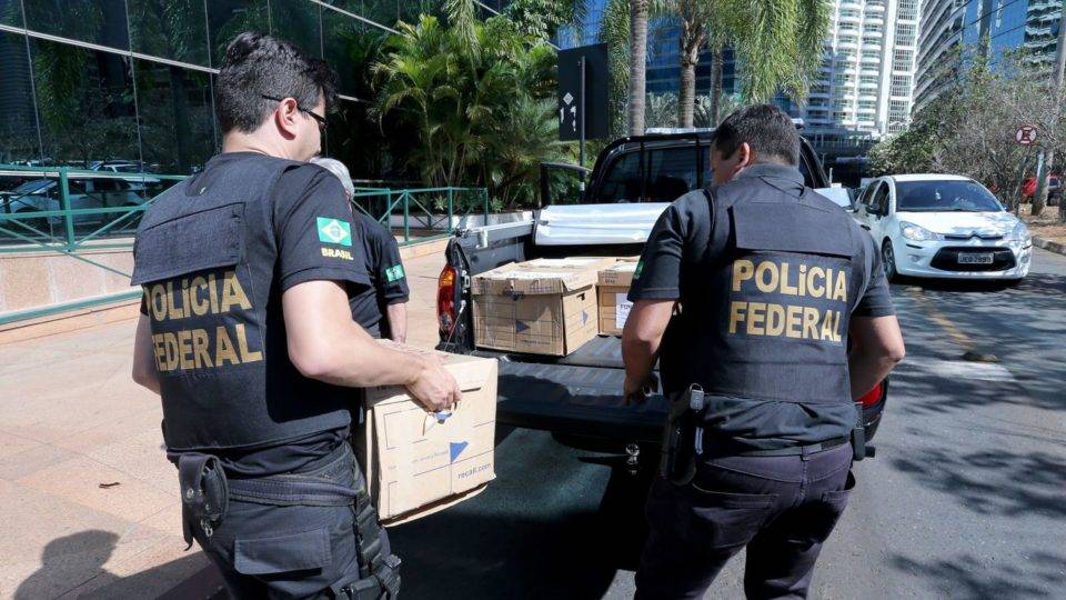 Agentes da PF colocam caixas em uma carro